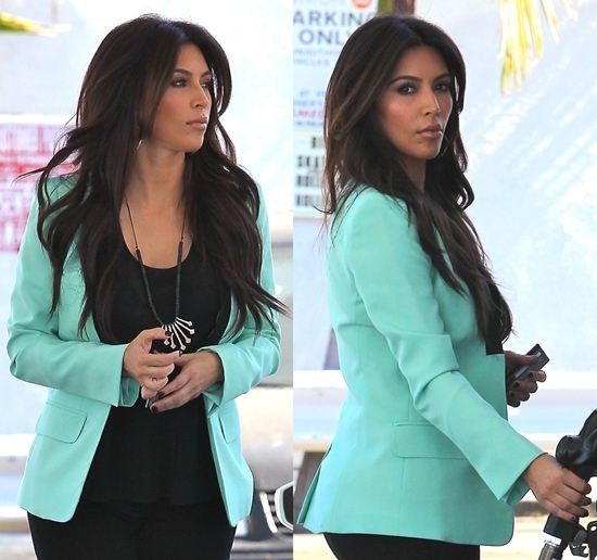 Kim Kardashian in loose black tank top and black skinny jeans topped off by a mint green blazer