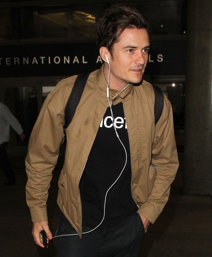 Orlando Bloom wears a bomber jacket while making his way out of LAX airport