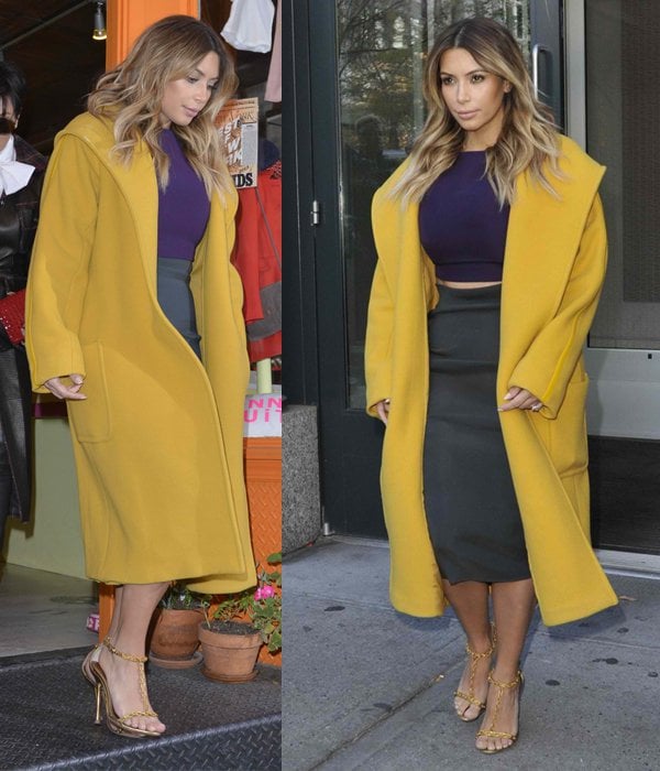 Kim Kardashian bundled up in a heavy maxi coat to fend off the cold but kept a part of her tummy