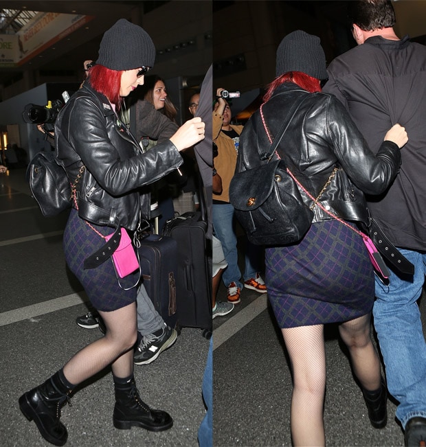 Katy Perry sporting bright red-dyed hair under a black beanie hat