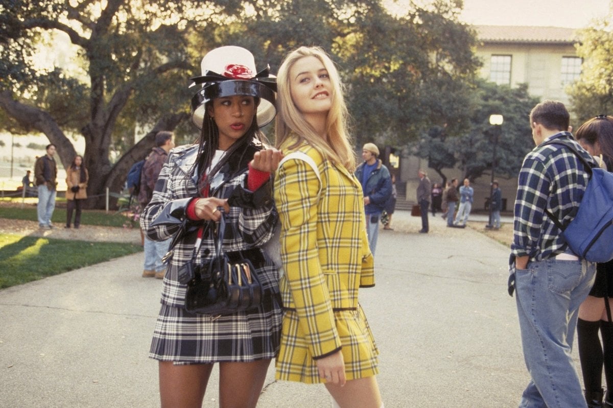 Alicia Silverstone wears a yellow plaid jacket as Cher Horowitz with Stacey Dash in a matching plaid set as Dionne Davenport in the 1995 American coming-of-age teen comedy film Clueless