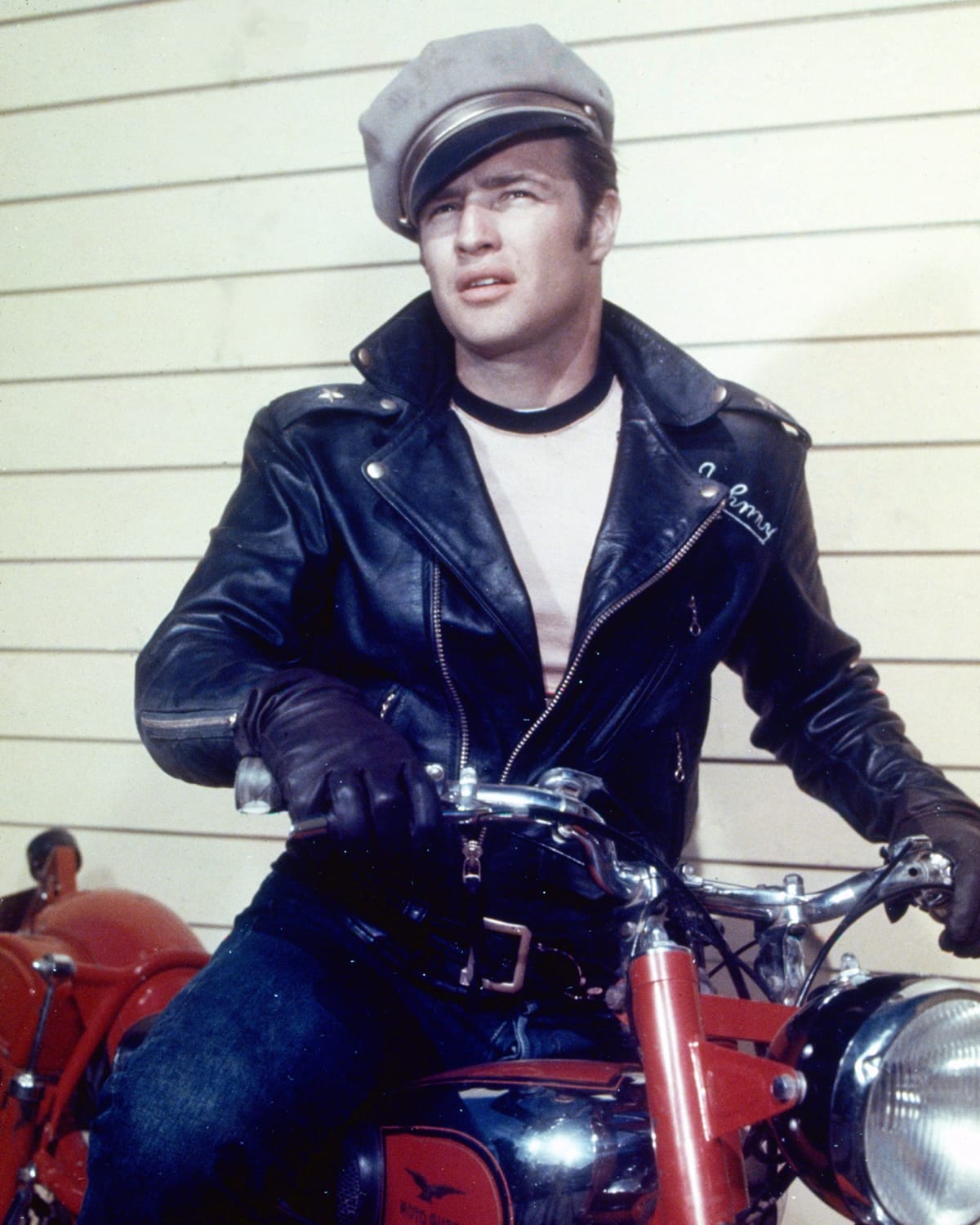 Marlon Brando wears a Perfecto-style motorcycle jacket and a tilted cap as Johnny Strabler in the 1953 American crime film The Wild One